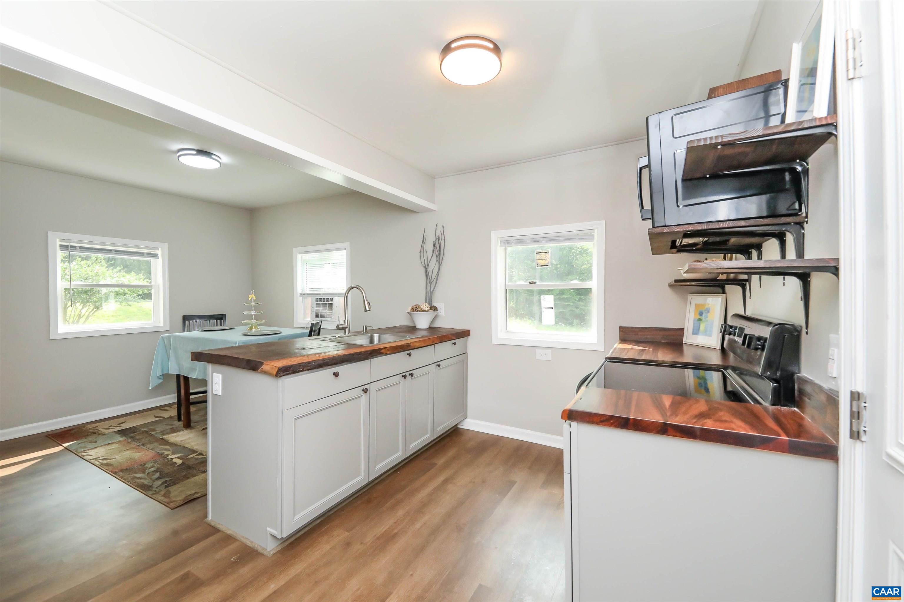 8901 Chestnut Grove Road Esmont, VA 22937 - Photo 13 of 44 a kitchen with a sink stove and wooden cabinets