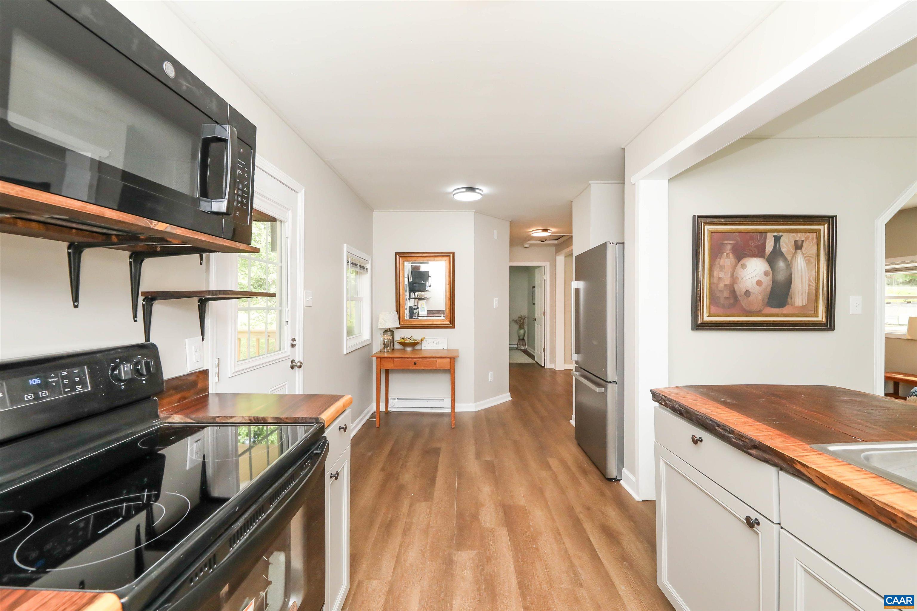 8901 Chestnut Grove Road Esmont, VA 22937 - Photo 2 of 44 a kitchen with granite countertop a stove and a wooden floors