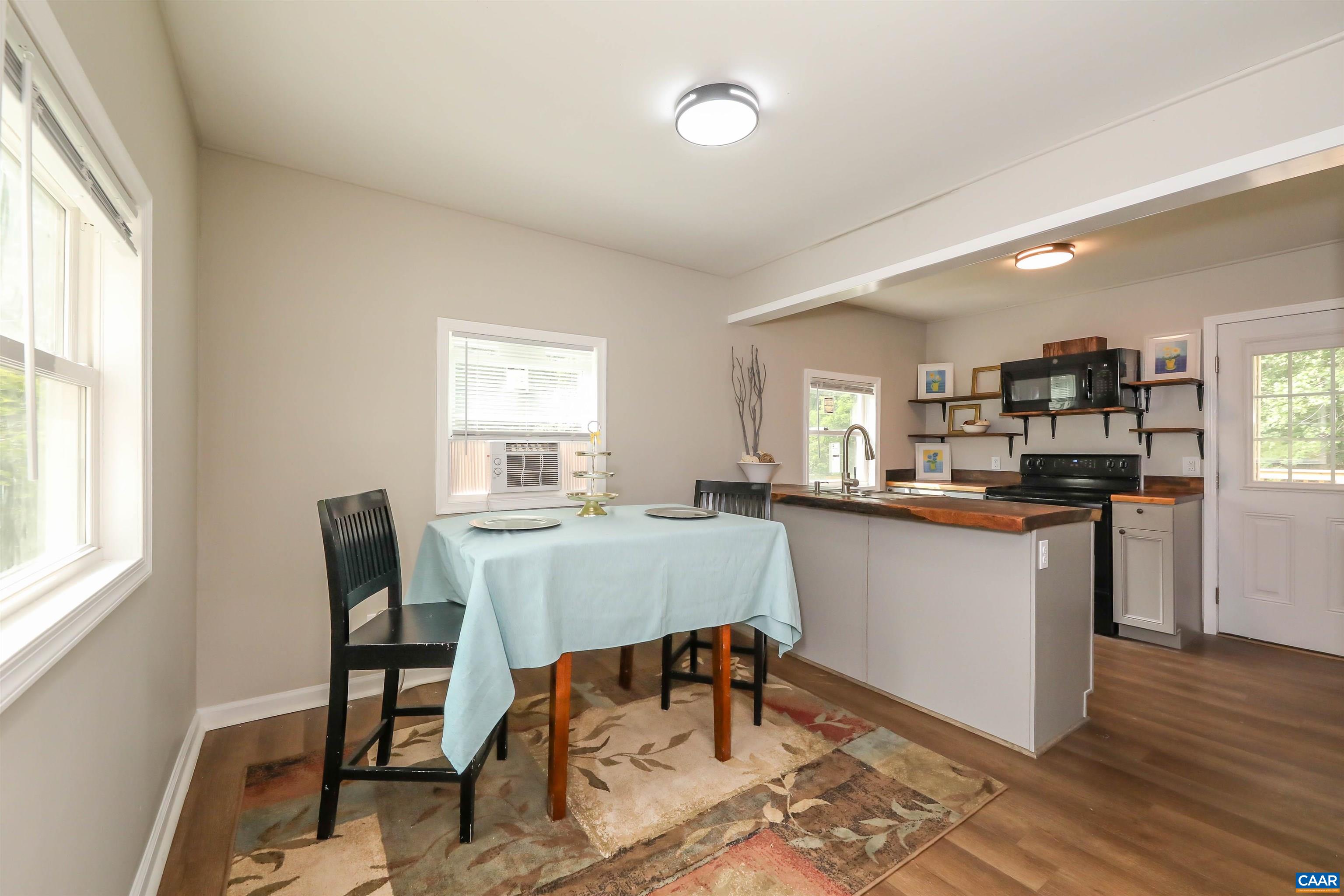 8901 Chestnut Grove Road Esmont, VA 22937 - Photo 4 of 44 a kitchen with a dining table chairs and refrigerator