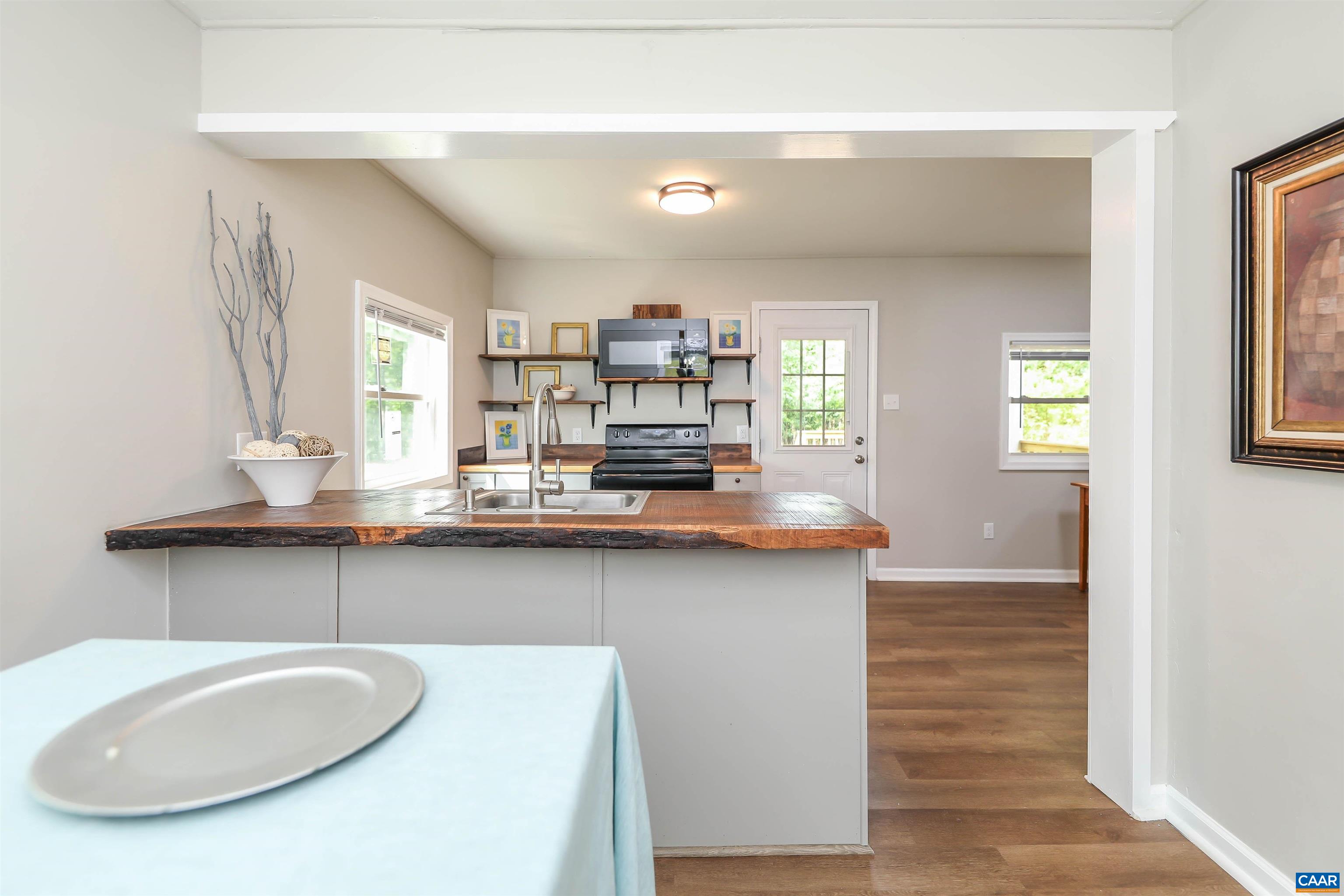 8901 Chestnut Grove Road Esmont, VA 22937 - Photo 10 of 44 a kitchen with stainless steel appliances granite countertop a sink a stove and a wooden floors