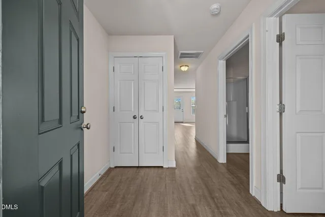 a view of a hallway with wooden floor