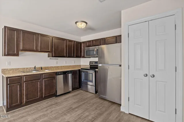a kitchen with stainless steel appliances granite countertop a refrigerator and a sink