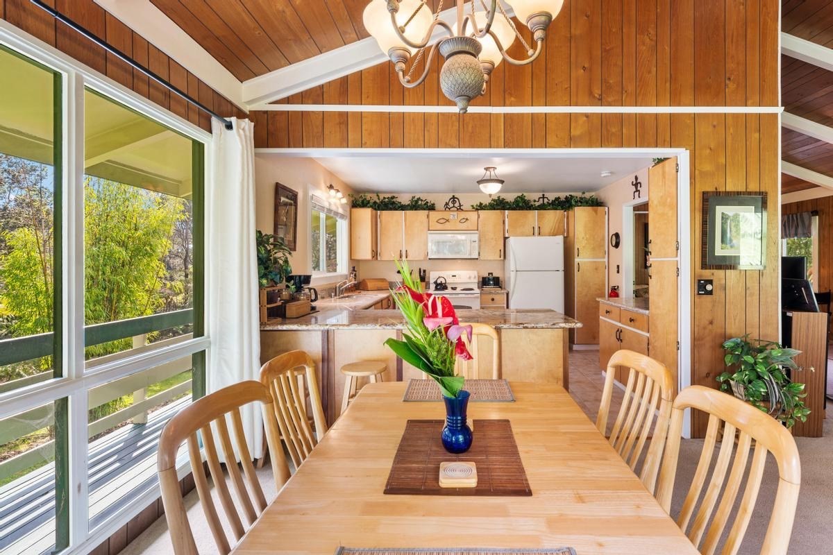 19-4252 Wright Road Volcano, HI 96785 - Photo 12 of 30 a view of a dining room with furniture wooden floor and a chandelier