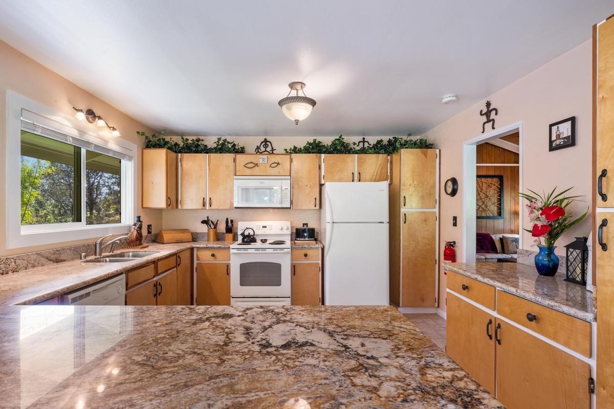 19-4252 Wright Road Volcano, HI 96785 - Photo 13 of 30 a kitchen with granite countertop a refrigerator and a sink