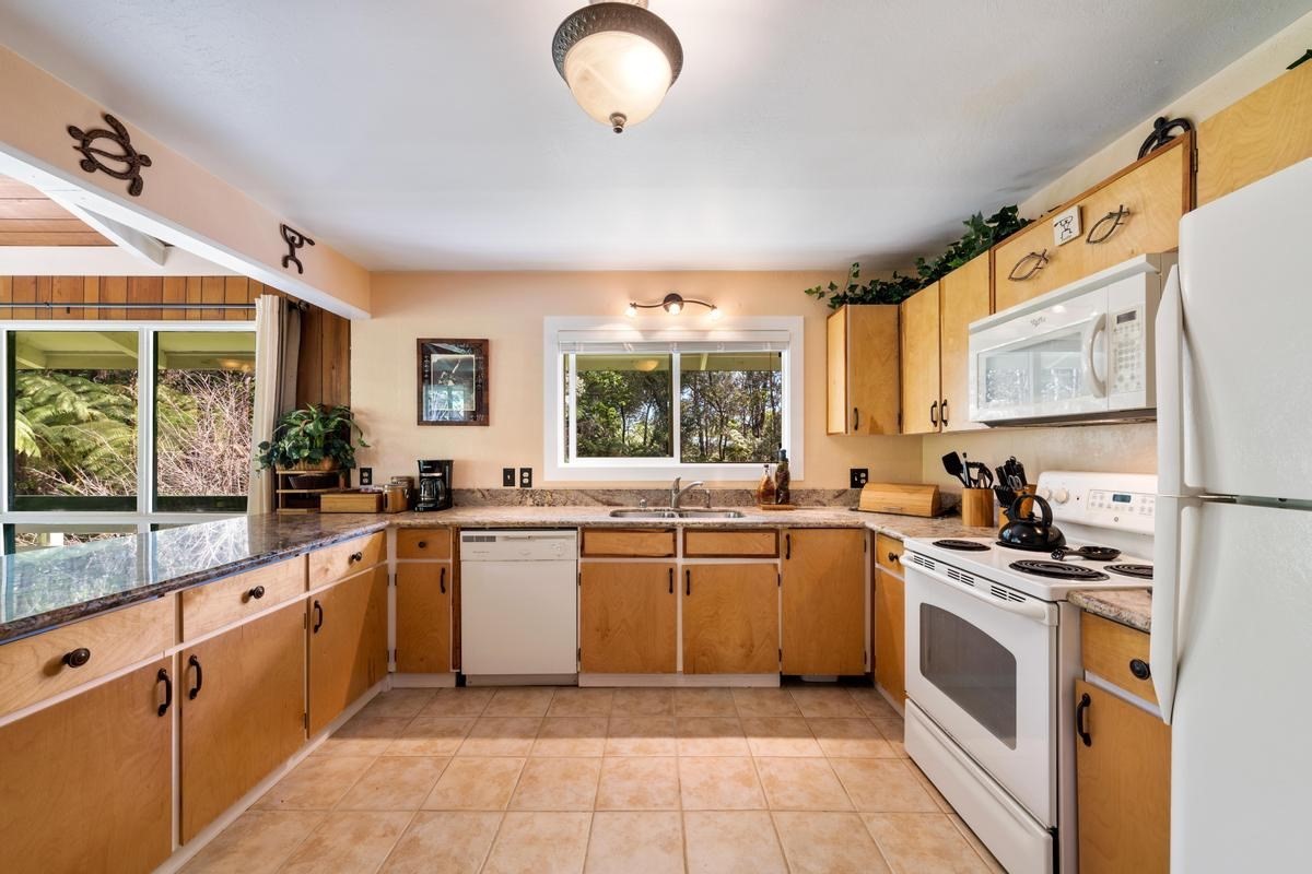 19-4252 Wright Road Volcano, HI 96785 - Photo 16 of 30 a kitchen with stainless steel appliances a stove sink and cabinets