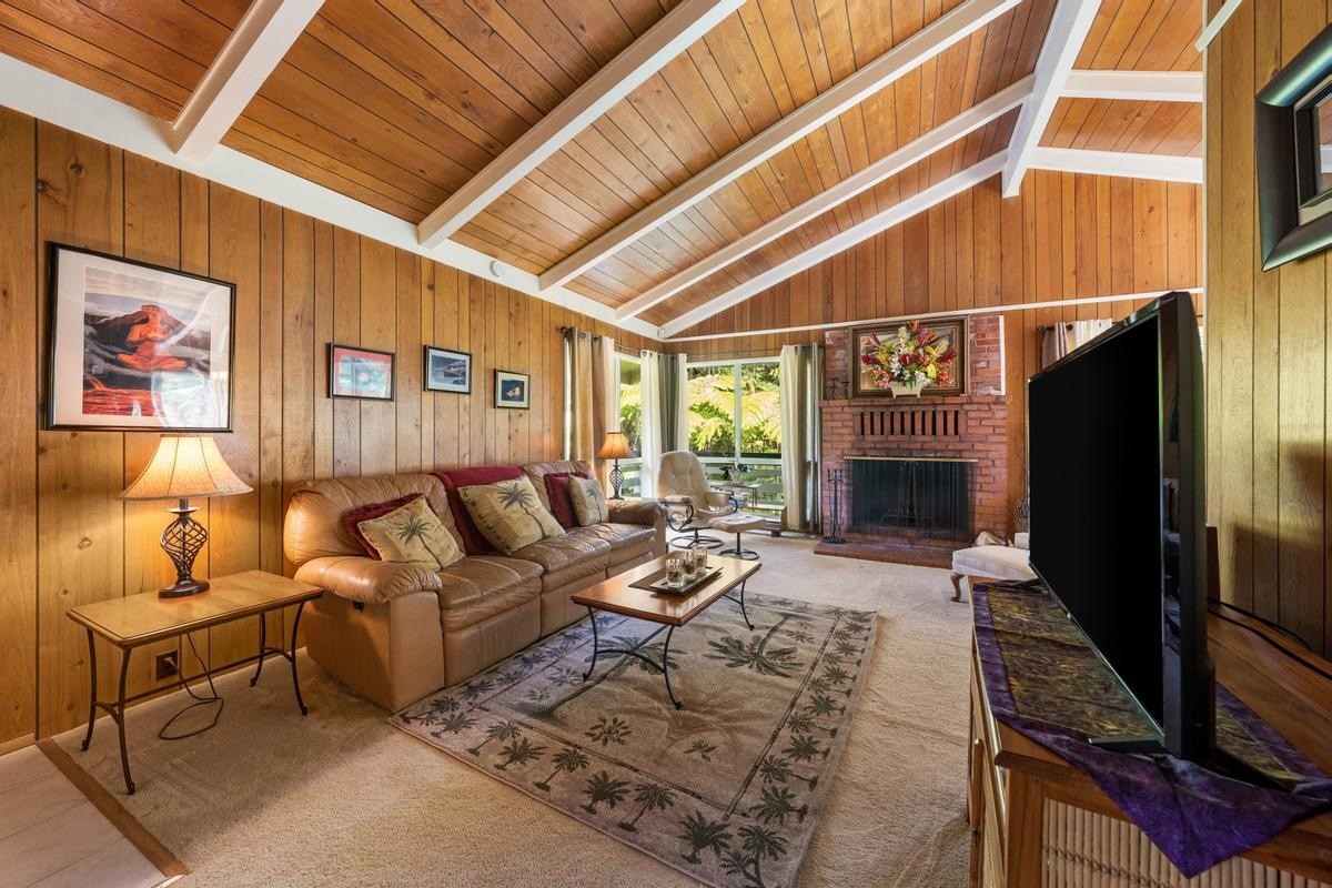 19-4252 Wright Road Volcano, HI 96785 - Photo 8 of 30 a living room with furniture a fireplace and a flat screen tv