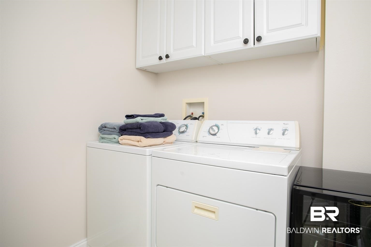 27800 Canal Road, Unit 411 Orange Beach, AL 36561 - Photo 31 of 49 Laundry area featuring white cabinetry with dark hardware, a built-in appliance hookup, and neutral wall tones
