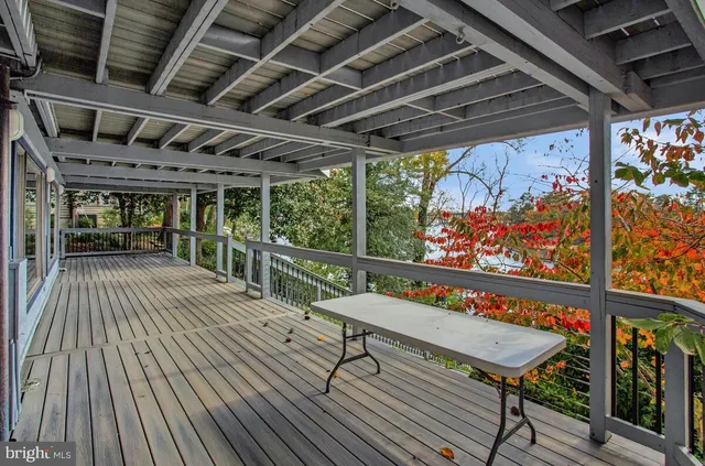 a view of a chairs and table on the wooden roof deck