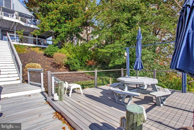 a view of a patio with couches table and chairs with wooden floor and fence