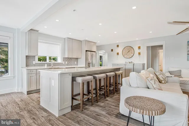 a living room with kitchen island granite countertop furniture and a large window