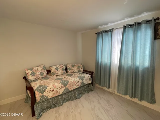 a bed sitting in a balcony next to a window