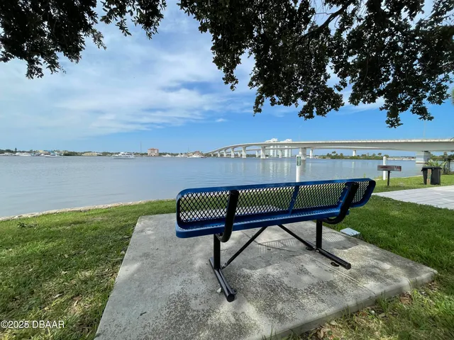 a view of a lake with a bench in a garden