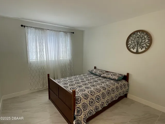 a bed sitting in a bedroom next to a window