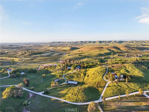 a view of a hallway with wooden floor and a chandelier