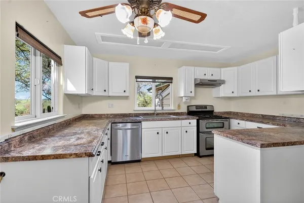 a kitchen with granite countertop a sink stove and cabinets