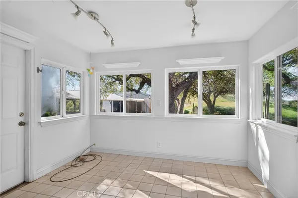 a view of a room with wooden floor ceiling fan and window