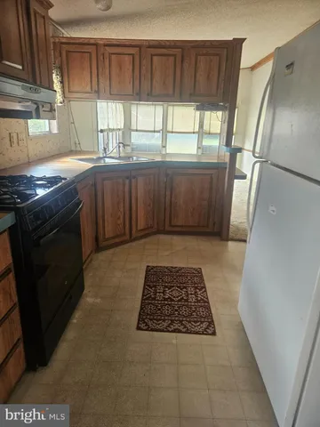 a kitchen with a stove a refrigerator and a window