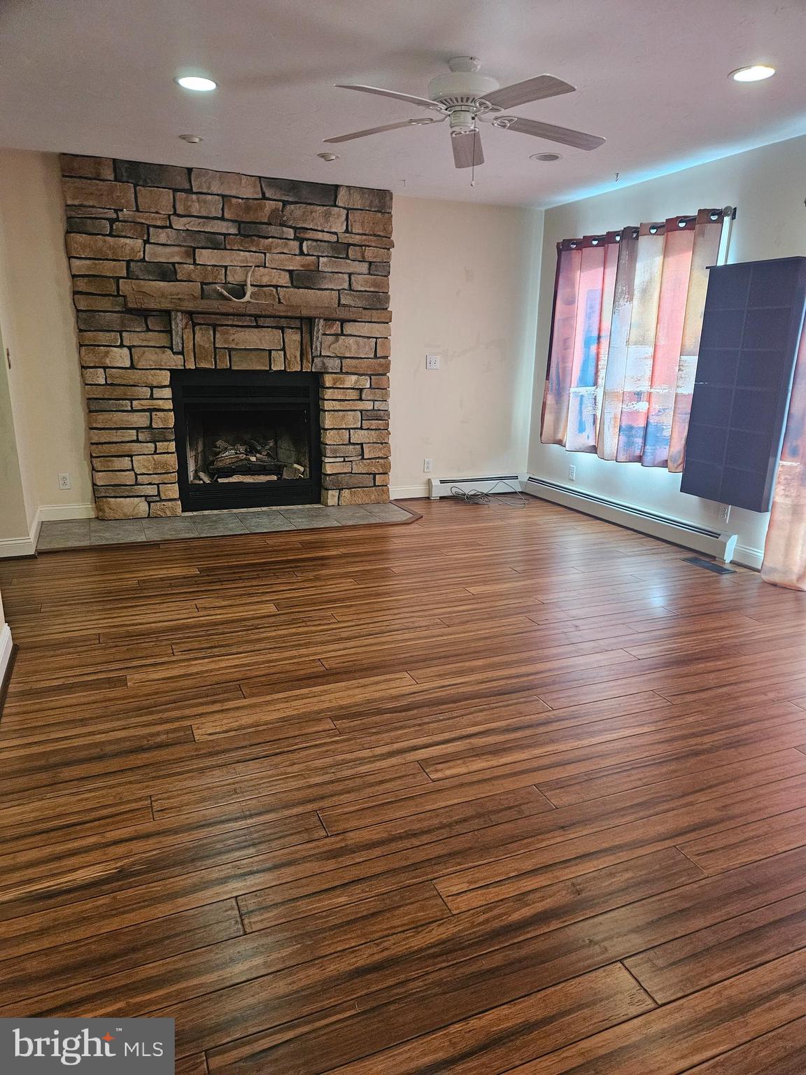 333 Newcomer Road Windsor, PA 17366 - Photo 10 of 25 an empty room with wooden floor fireplace and windows
