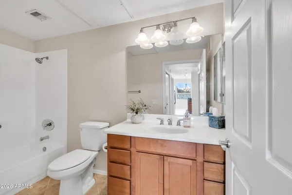 an empty room with a ceiling fan and carpet