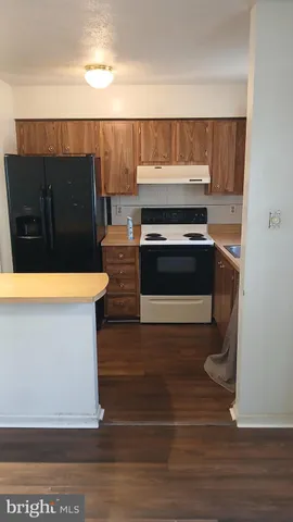 a kitchen with stainless steel appliances a sink a stove a refrigerator and cabinets