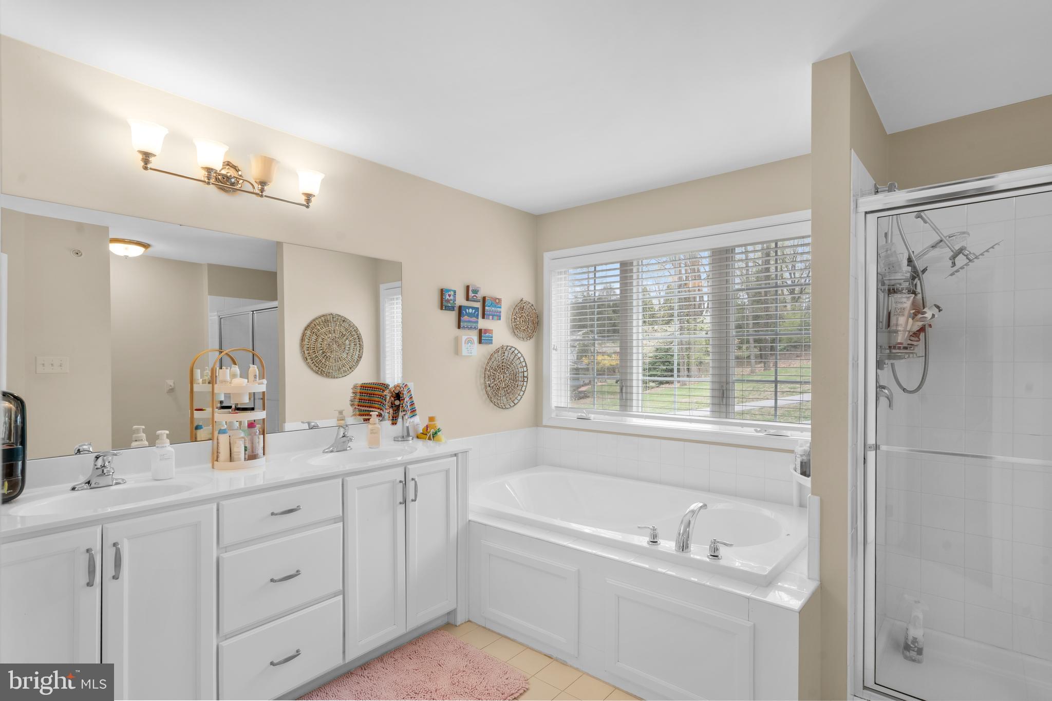 776 Barry Drive Springfield, PA 19064 - Photo 25 of 44 a bathroom with a tub a sink double vanity and a window