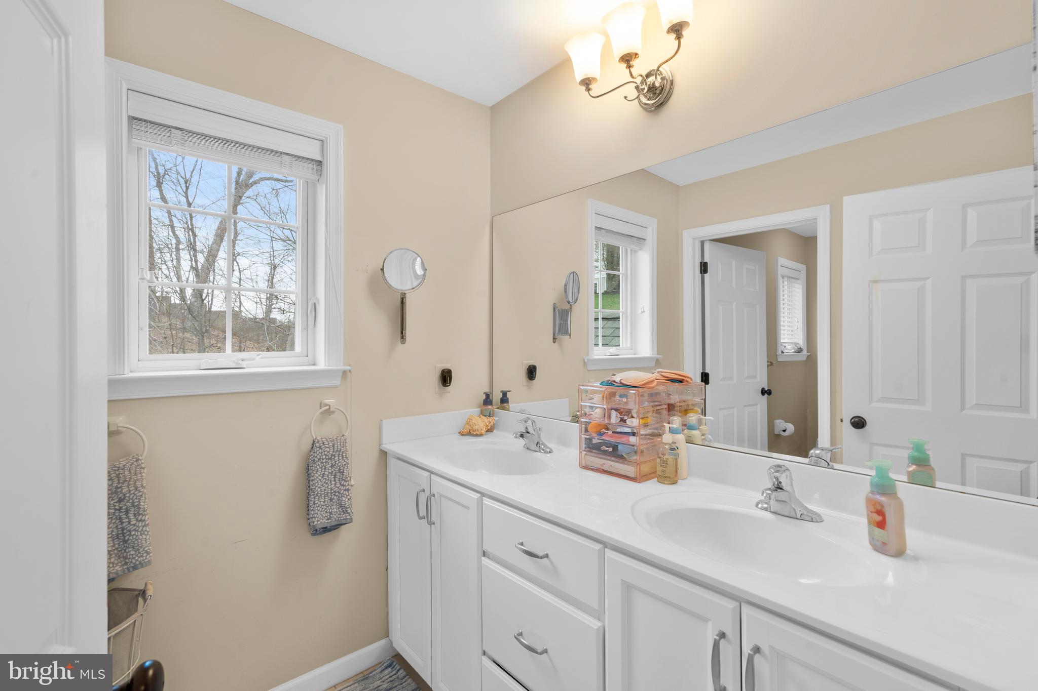 776 Barry Drive Springfield, PA 19064 - Photo 32 of 44 a bathroom with double vanity sinks a mirror and a window