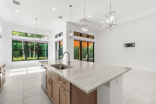 an open kitchen with stainless steel appliances kitchen island granite countertop a refrigerator and a sink