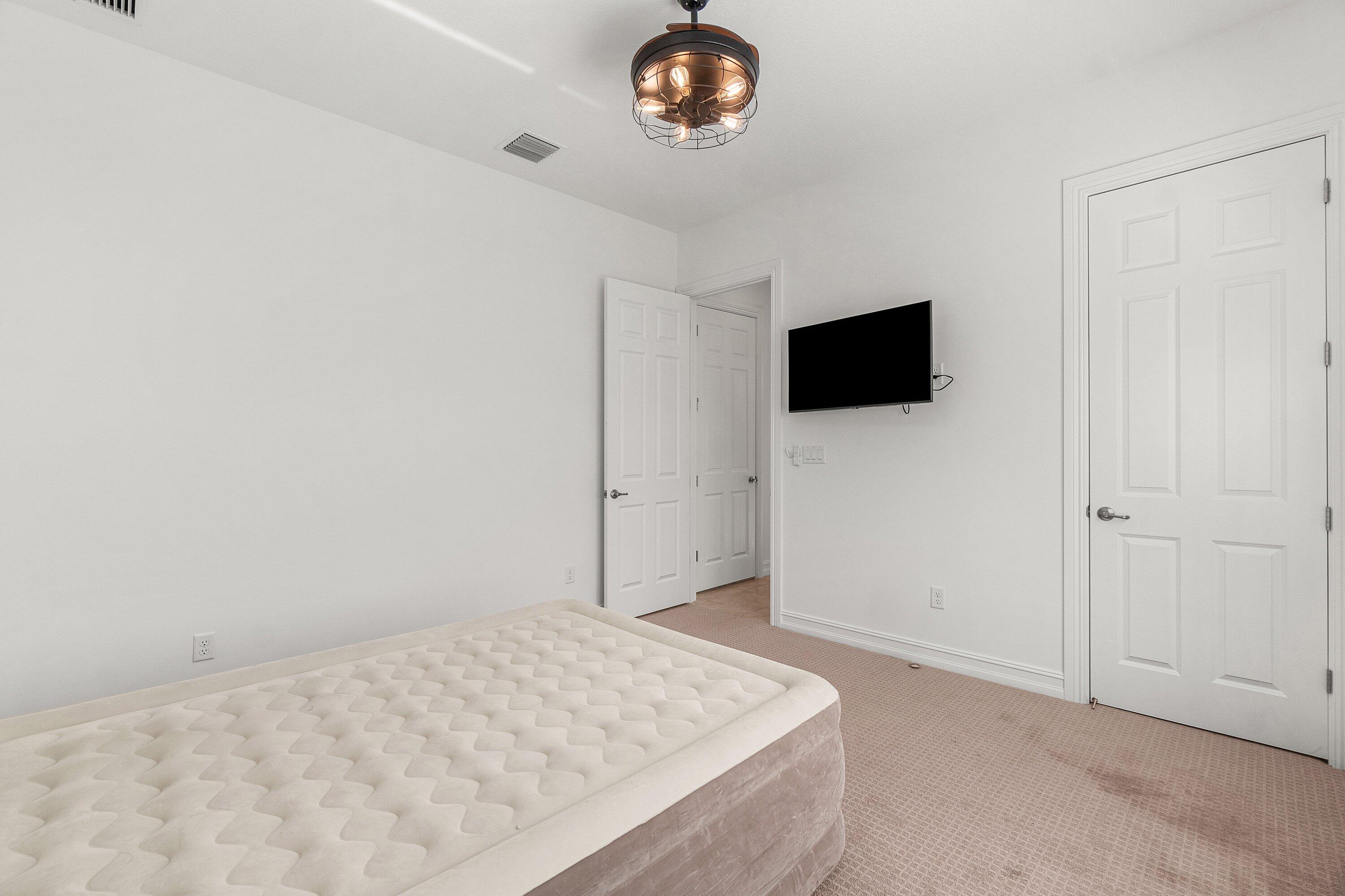 11902 Palermo Road Parkland, FL 33076 - Photo 32 of 48 a bedroom with a bed and a flat screen tv