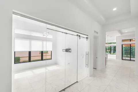 a large white kitchen with a large window and stainless steel appliances