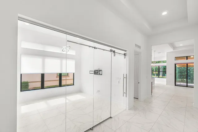 a large white kitchen with a large window and stainless steel appliances