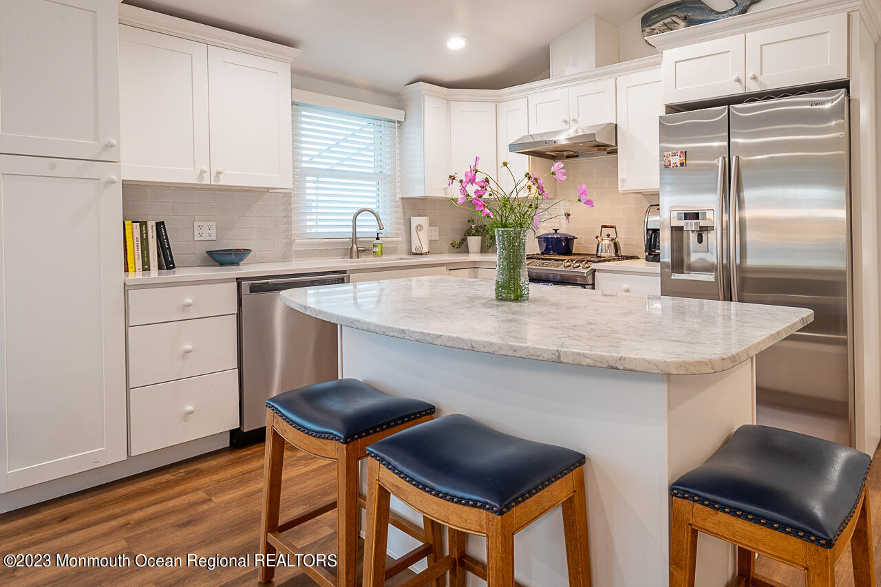 337 Kingfisher Road Tuckerton, NJ 08087 - Photo 12 of 41 a kitchen with stainless steel appliances kitchen island granite countertop a table chairs in it and wooden floors