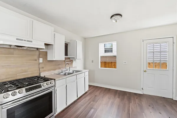 a kitchen with a stove and white cabinets