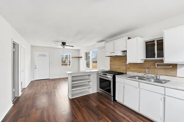 a kitchen with granite countertop a stove and cabinets