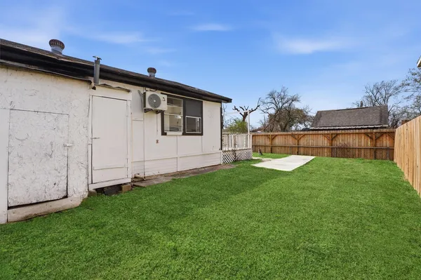 a view of a backyard with wooden fence and a bench
