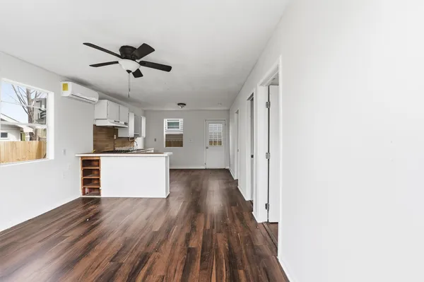 a view of a kitchen with wooden floor a sink and dishwasher