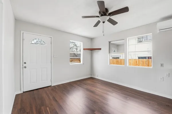 a view of empty room with wooden floor and fan