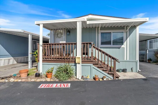 a view of a house with porch and wooden fence