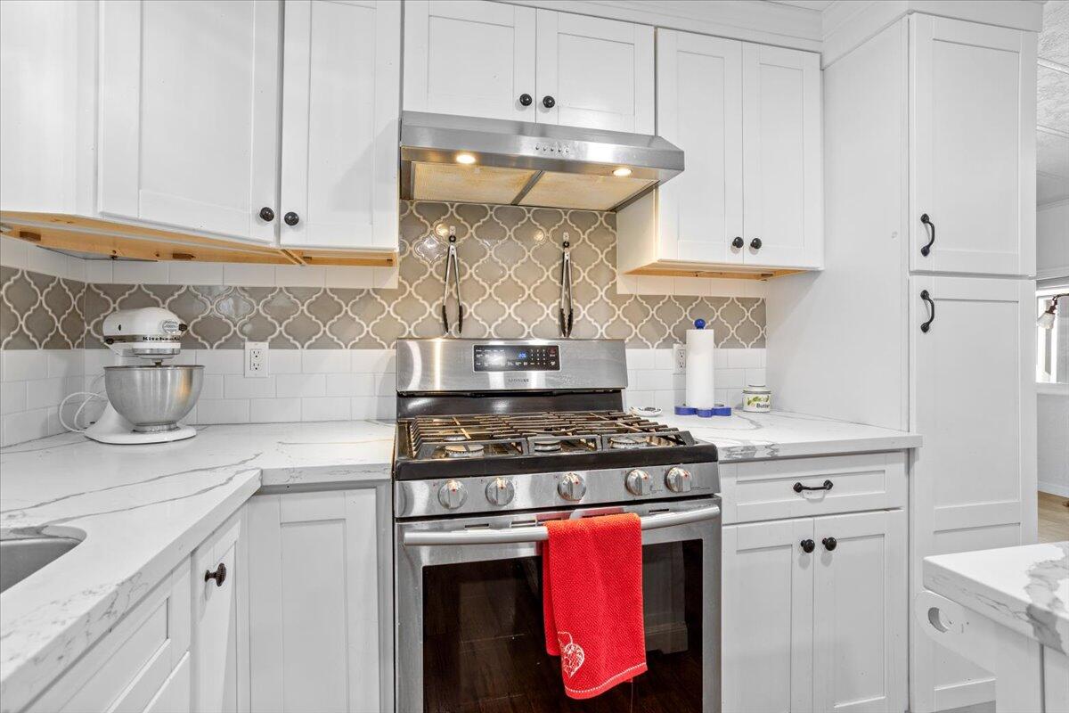 5700 Via Real, Unit 106 Carpinteria, CA 93013 - Photo 12 of 26 a kitchen with stainless steel appliances granite countertop a stove and a white cabinets