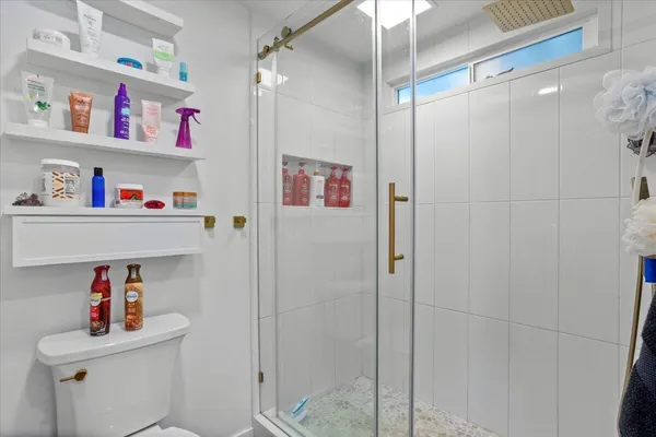 a bathroom with a granite countertop sink a mirror and a shower