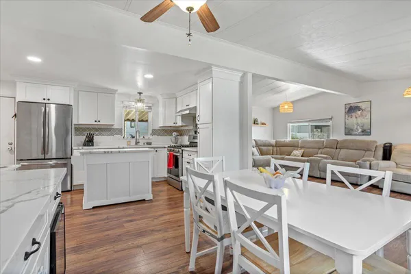 a kitchen with kitchen island a stove a table and chairs