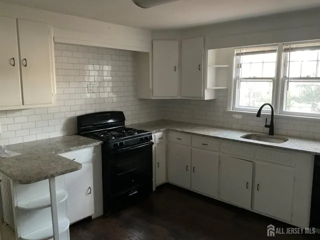 a kitchen with stainless steel appliances granite countertop a sink stove and cabinets