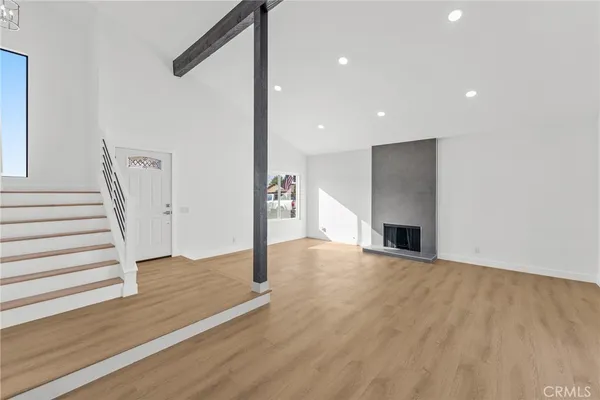a view of empty room with wooden floor and fireplace