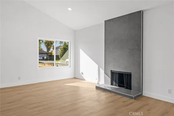 an empty room with windows and fireplace