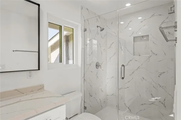 a bathroom with a shower sink vanity and mirror