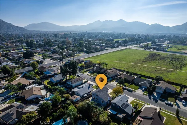 an aerial view of a city with lots of residential buildings ocean and mountain view in back