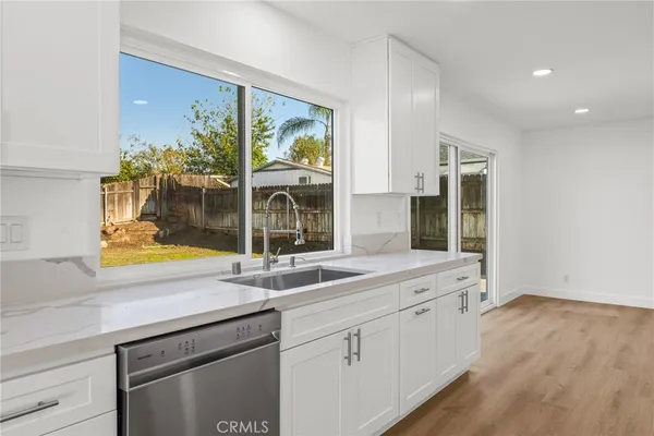 a kitchen with a sink and wooden floor