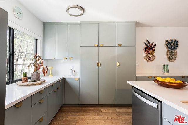 a kitchen with stainless steel appliances cabinets and wooden floor