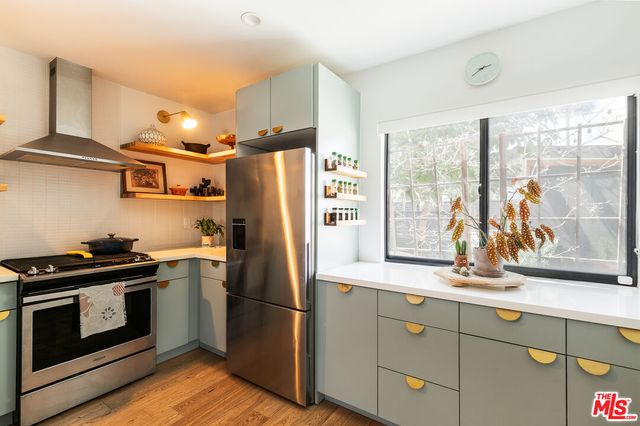 a kitchen with stainless steel appliances a refrigerator a stove and wooden cabinets