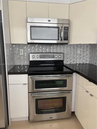 a stove top oven sitting inside of a kitchen