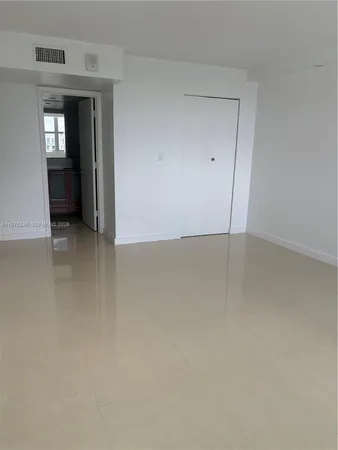 an empty room with closet and mirror